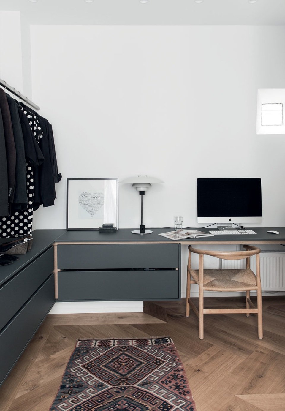 The couple's walk-in closet which is also the office. A bright PP201 Hans Wegner chair is used as office chair, and PH 4/3 lamp by Poul Henningsen tables and drawers in made of linoleum, which lends to a soft subdued look.