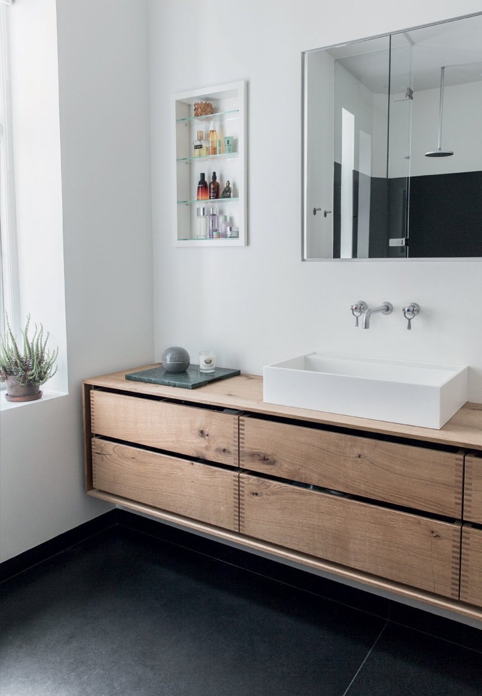 The fittings in the bathroom are made of oak planks treated with natural oil. Two large granites slices constitute the floor, creating at the same time a raw and soft contrast.