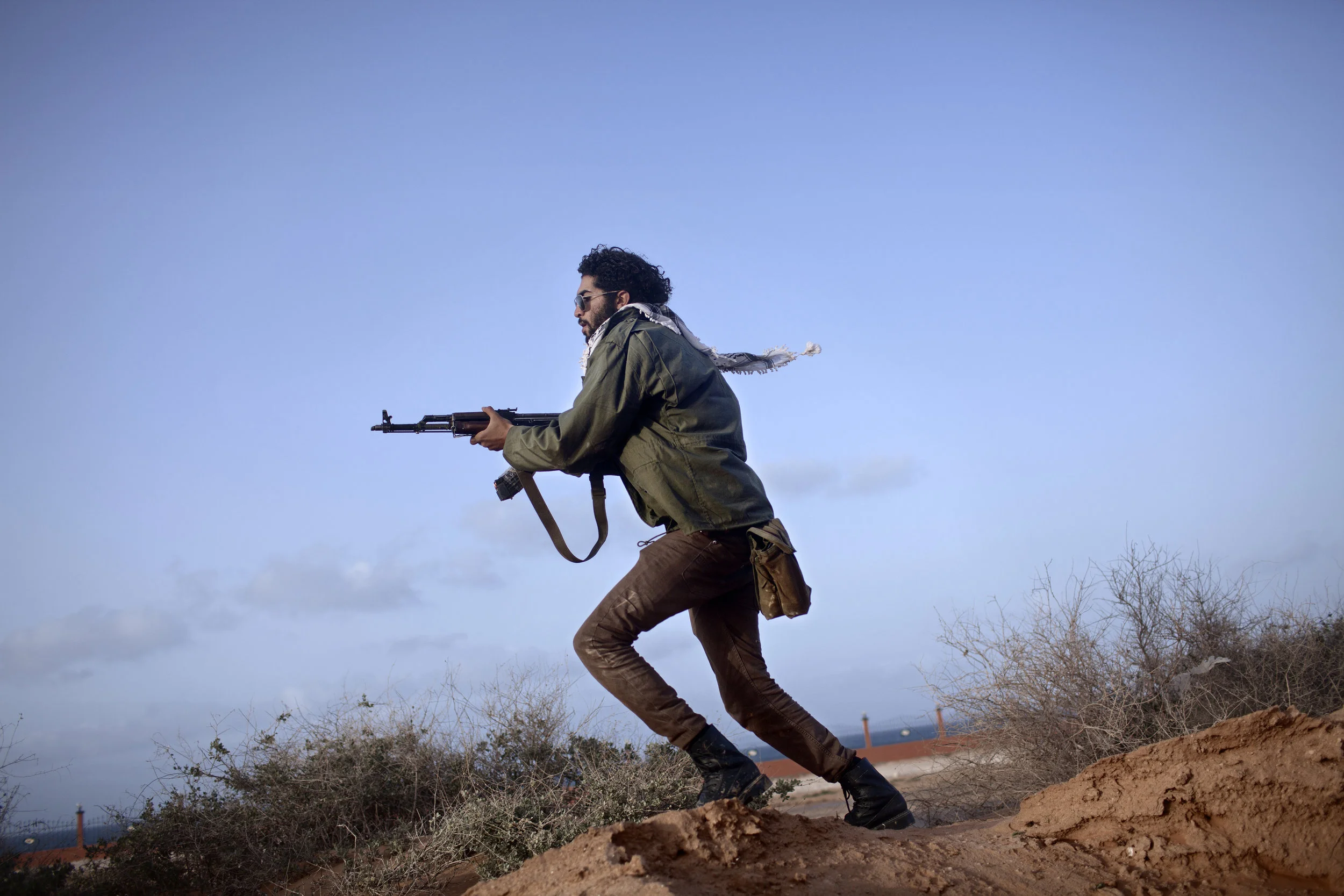  3/5/2011 Bin Jawad, Libya  An Anti-Qaddafi fighter armed with an Kalashnikov assault rifle cleared an area near the front line, in Bin Jawad, on March 5, 2011. The next day, forces loyal to Col. Qaddafi would launch a counter-attack that would ultim