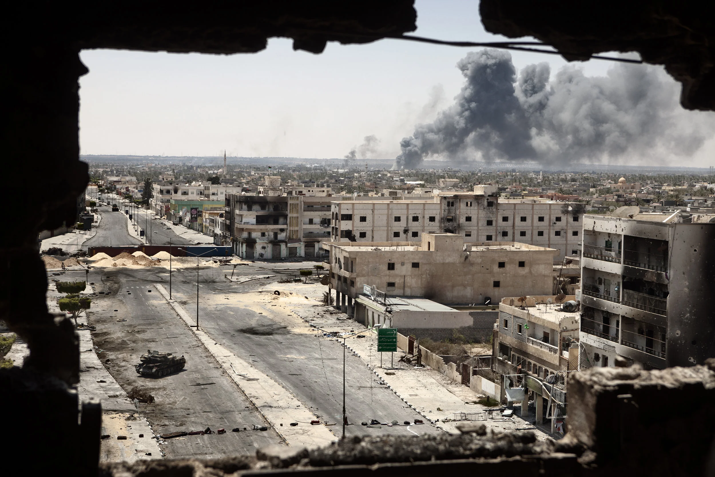  4/29/2011 Misurata, Libya  During the seige of the city, Smoke billowed from a shoe factor on the frontline near the airport, with the bombed out remains of buildings on Tripoli Street in the foreground, in Misurata. 