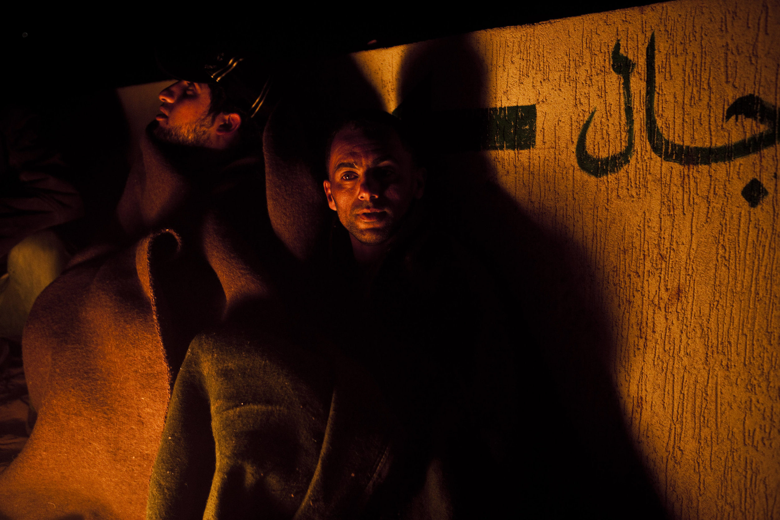  3/7/2011 Ras Lanuf, Libya  Anti-Gaddafi rebels warmed themselves by a fire in the early morning near the frontlines outside of Ras Lanuf, Libya. The previous day, forces loyal to Muammar al-Gaddafi launched a forceful counterattack, halting the rebe