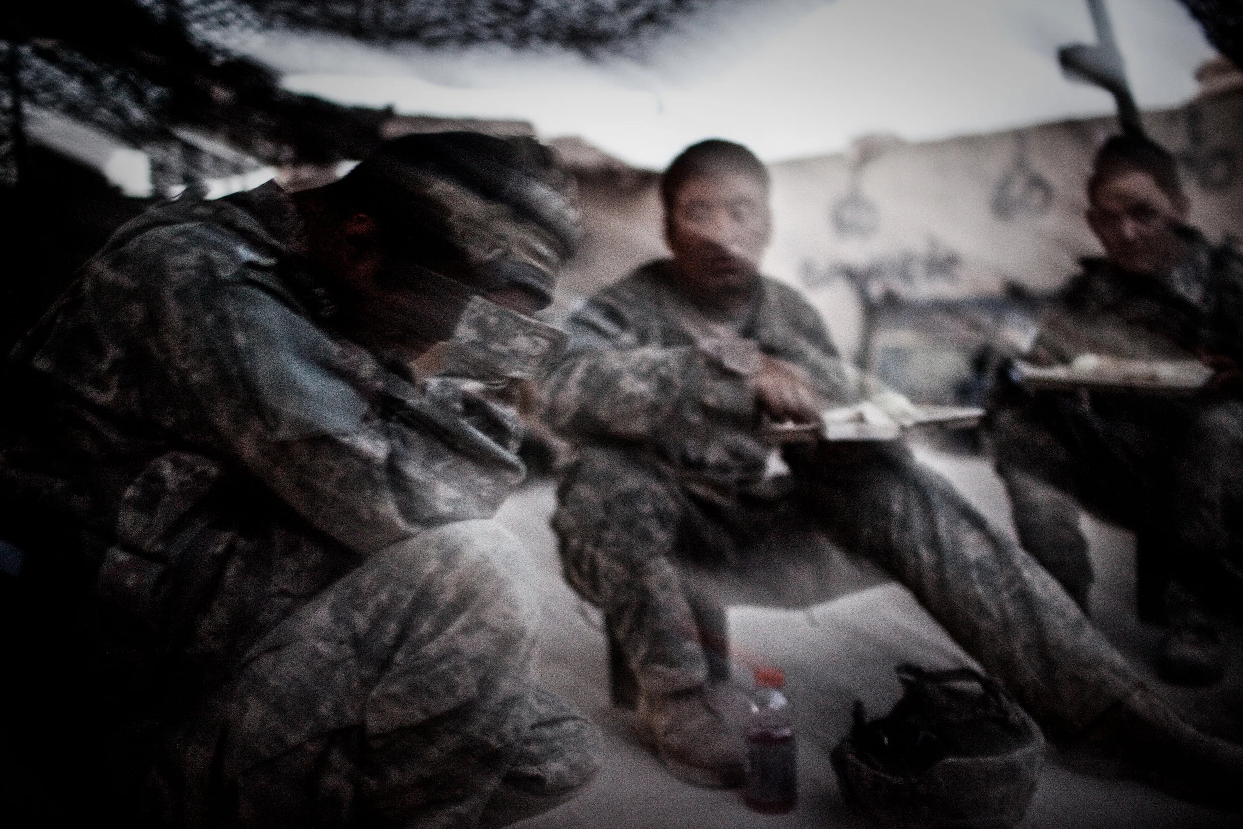  Combat Outpost Nolen, Arghandab District, Kanahar Province, Afghanistan. 2010  Sgt Zavala (L) of 1-320 FAR, 101st Airborne reflected on the days events on the roof of Strong Point Lugo as his comrades ate dinner nearby, following a heavy firefight t