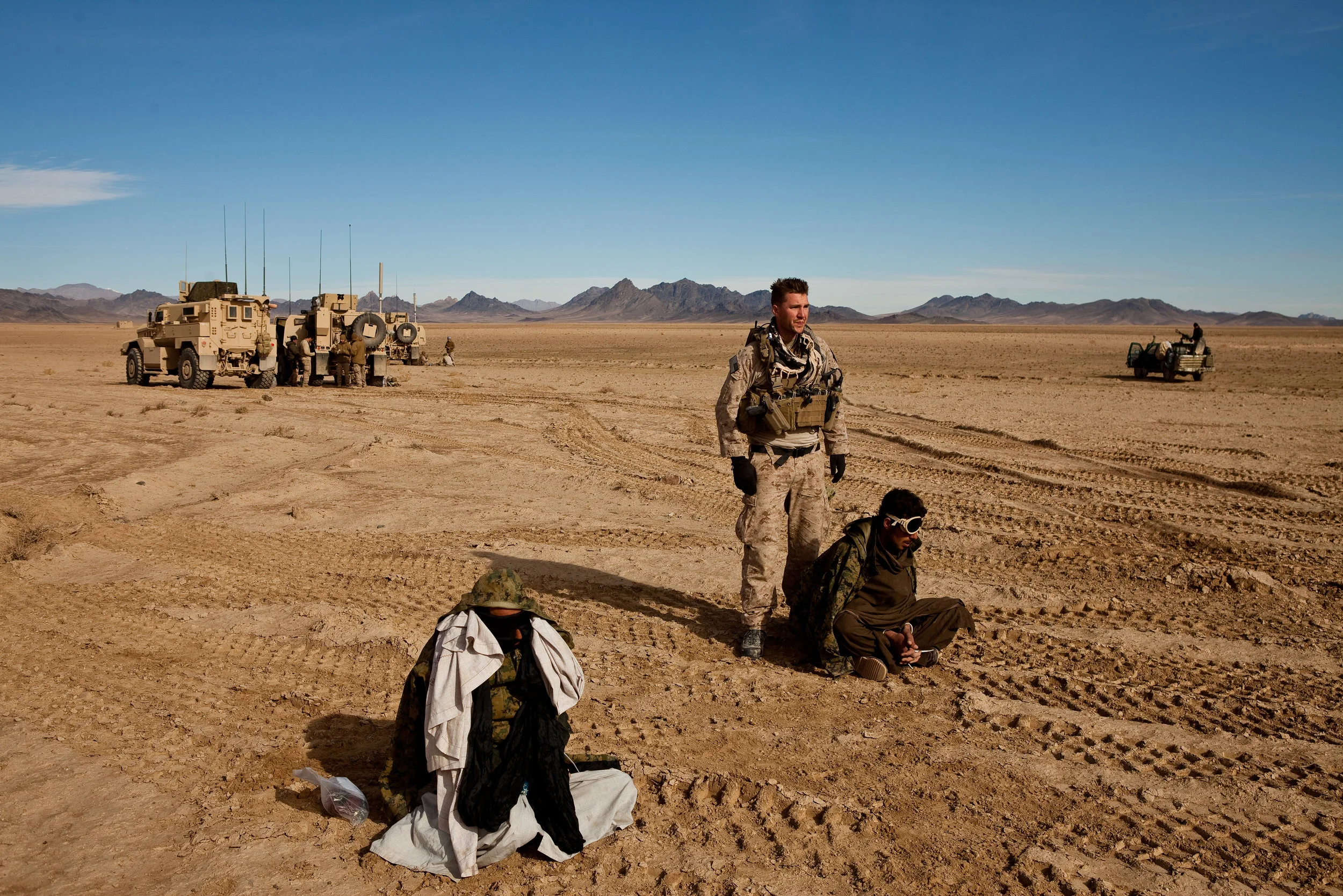 Washir Valley, Helmand Province, Afghanistan. 2009  A US Marine of 3rd Recon Battalion stand watch over two flindfolded and bound suspected Taliban insurgents who were detained after they were stopped fleeing a village. Liquid based tests of their h