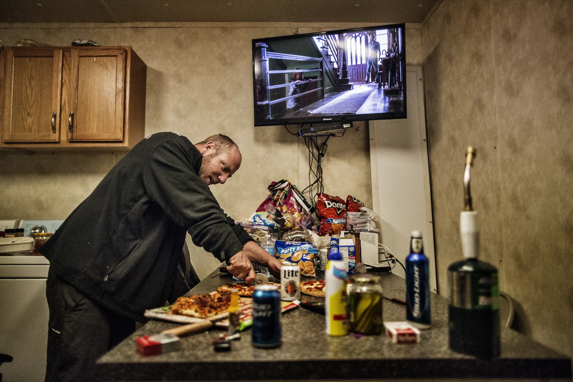  7/26/2014 East of Watford City, North Dakota  "Bam" sliced a microwave pizza he made for dinner at the Raven Drilling “man camp” near to their drill site. Four six man crews trade off working two crew/two week shifts, with each shift lasting 12 hour