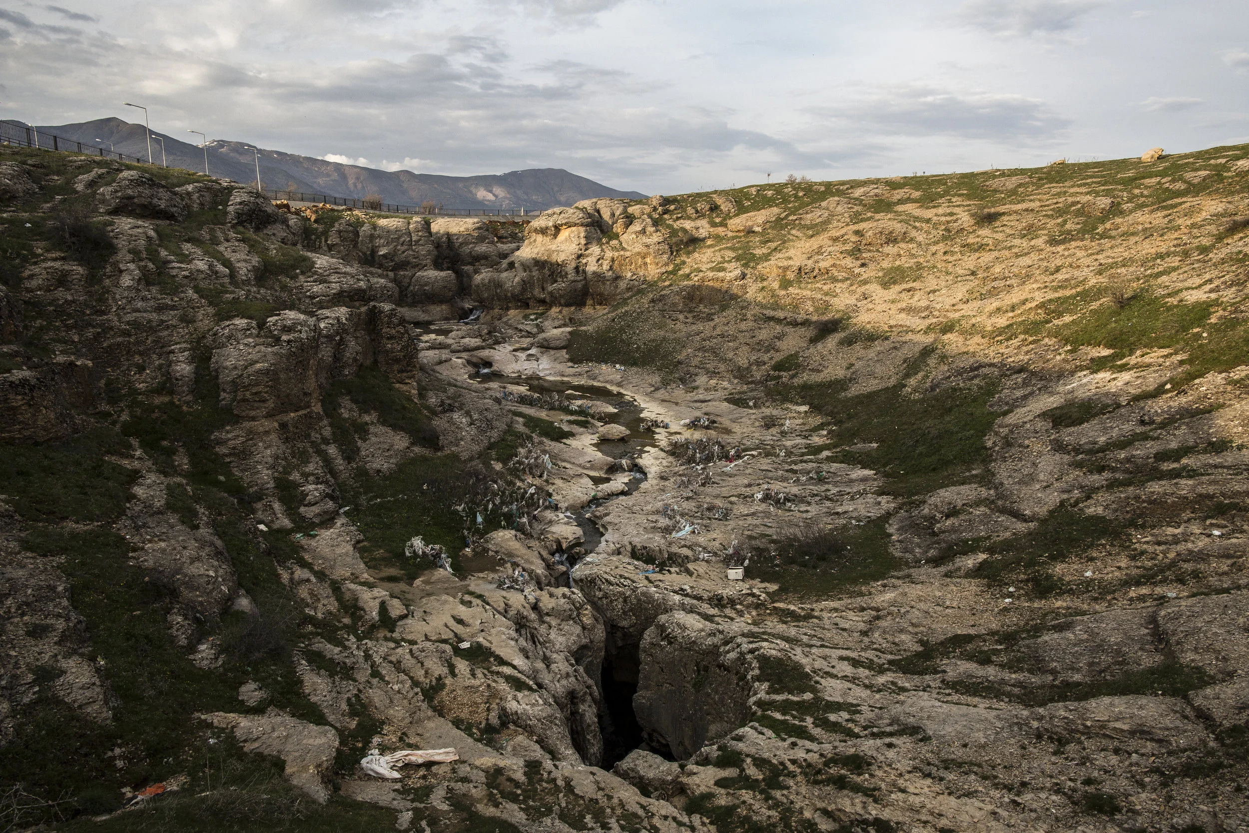  3/18/2015 Çüngüş, Turkey  A small stream flows into the Dudan cave, pictured here, which drops several hundred feet into darkness. It was here that the Armenian residents of the village of Çüngüş are said to have been thrown, after being led there b