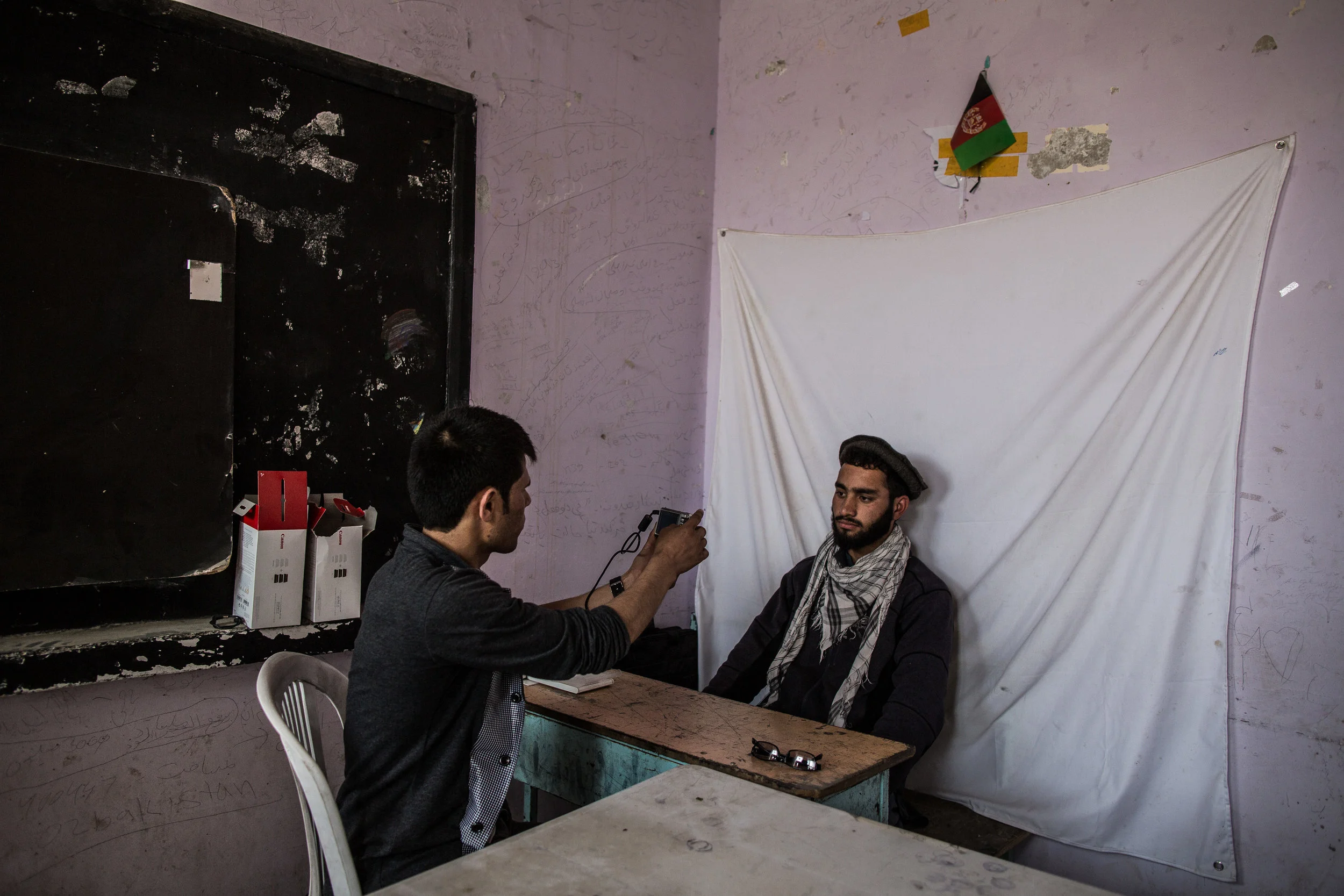 3/31/2014 Kabul, Afghanistan A man had his picture taken at a voter registration center in Kabul, Monday.
