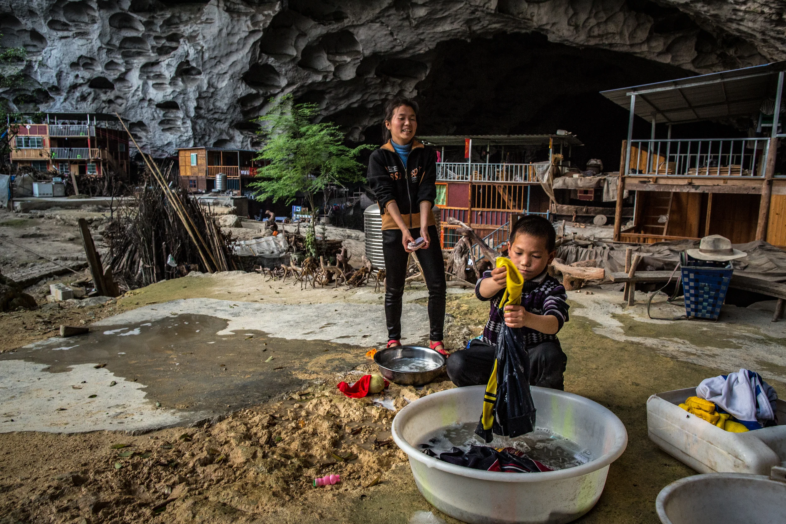 4/13/2018 Zhongdong, Guizhou Province, China. Young residents of the Zhong cave did their laundry during their weekend break from boarding school. Much of Childrens weekends at home are occupied by housework and farming.