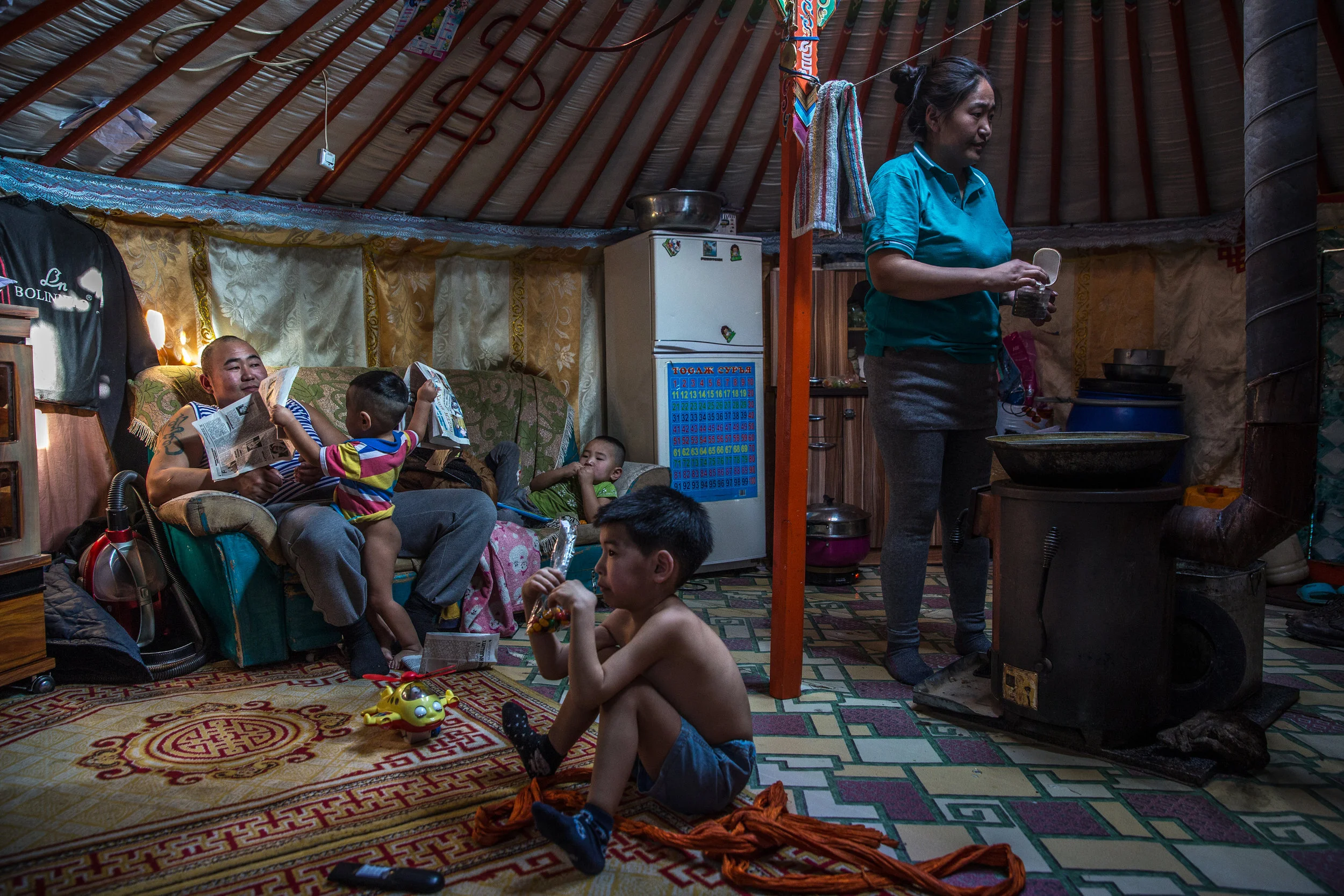  2/20/2018 Ulaanbaatar, Mongolia  Byambatseren Usukhbayar, 33, left, sat with his three sons in their Ger or yurt, as his wife, Mrs Orlom Namjildorj, 30, right, used their coal stove to prepare Mongolian milk tea. Mr. Usukhbayar works as a coal miner
