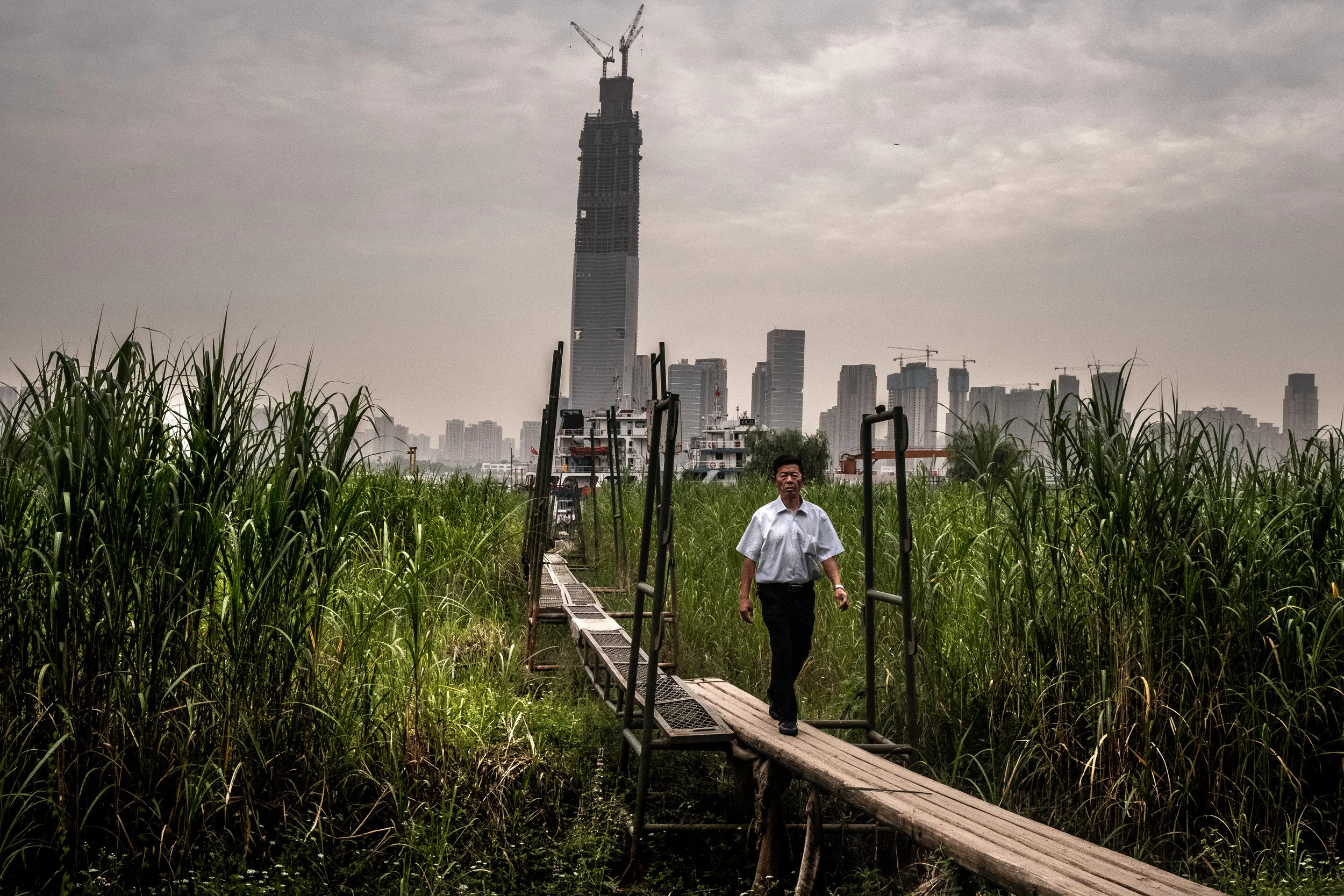  5/29/2018 Wuhan, China  A man walked along an elevated gangway from a riverside dock on the Yangtze in Wuhan, a former river town and colonial outpost that has swelled into a metropolis of over ten million. 