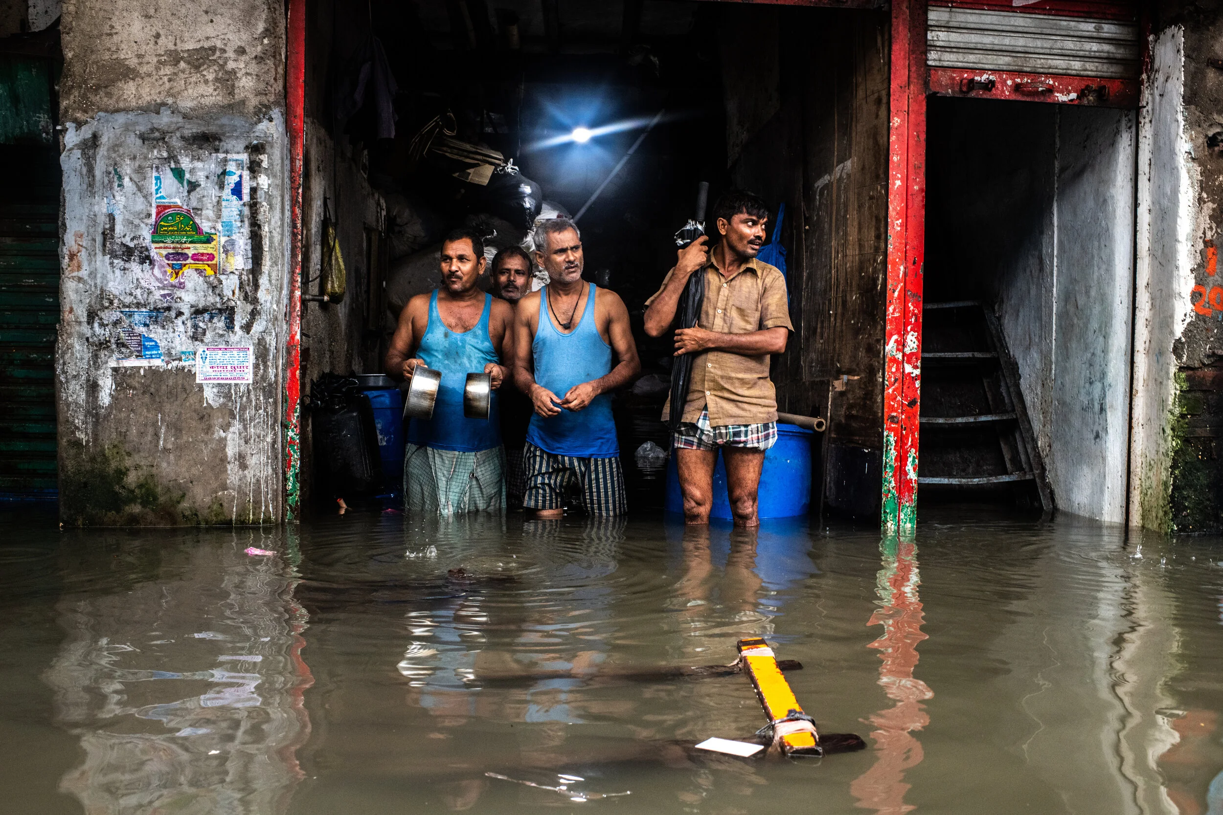  8/4/2019 Mumbai, India.   Shop keepers looked out on their flooded street during heavy monsoon rains in the Sion neighborhood of Mumbai, in early August. Mumbai, a megacity of over 15 million is particularly vulnerable to rising sea levels, and is c
