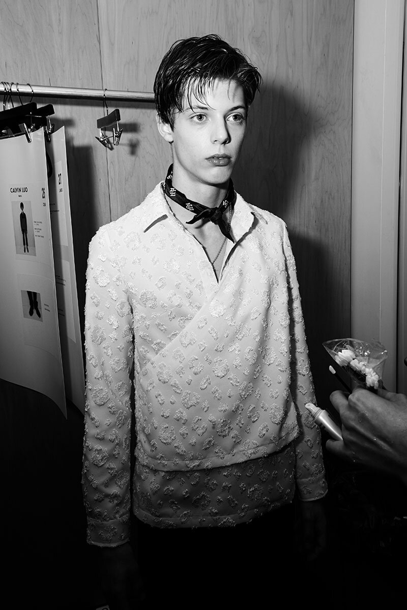 A male model in makeup backstage at Calvin Luo for Fall/Winter 2018.