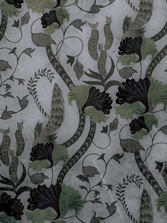 Close-up of a patterned fabric or wallpaper with stylized floral and vine design in shades of green, black, and gray on a light background.