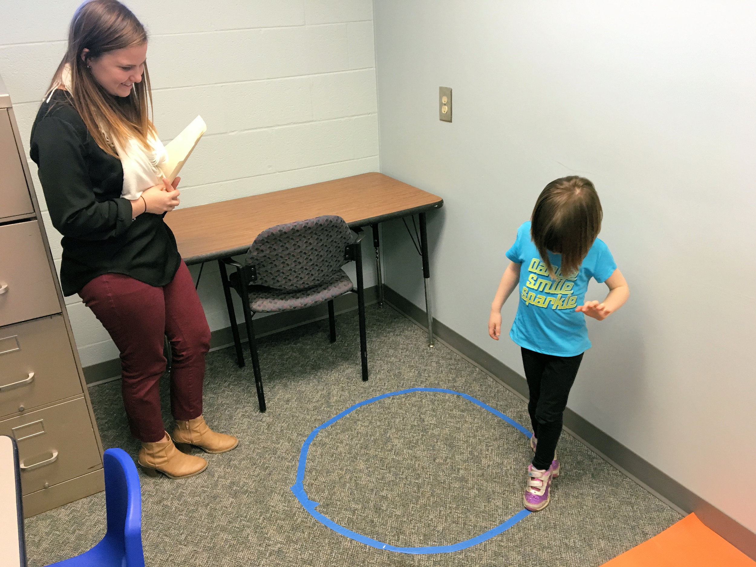 Children play games with a trained, child-friendly member of the lab.