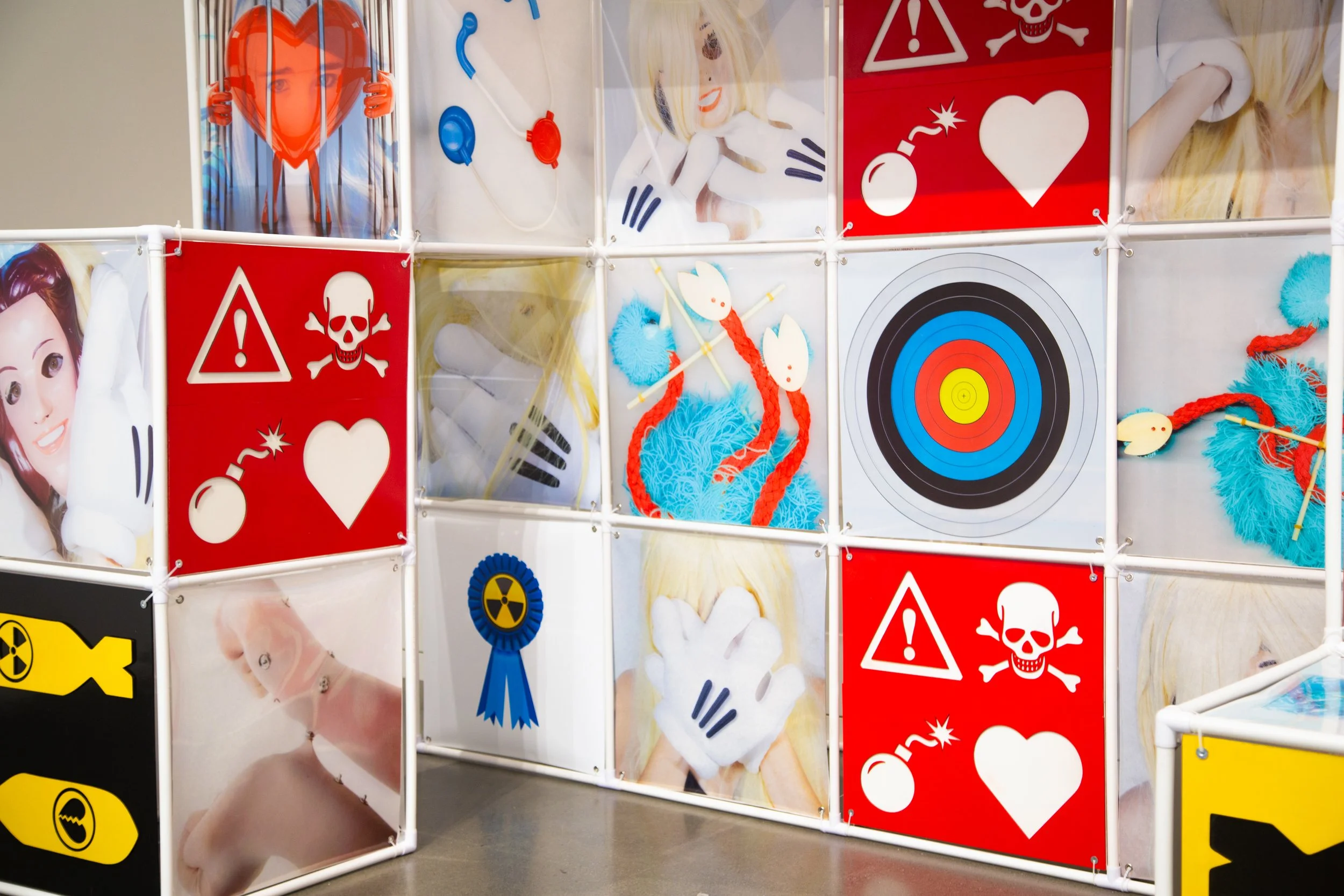 An Attraction (2025) Installation with polyvinyl chloride pipe, inkjet prints on celluloid film, maple plywood coated in federal standard Occupational Safety and Health Administration (OSHA) enamel paint and polyurethane high gloss, silver gromme