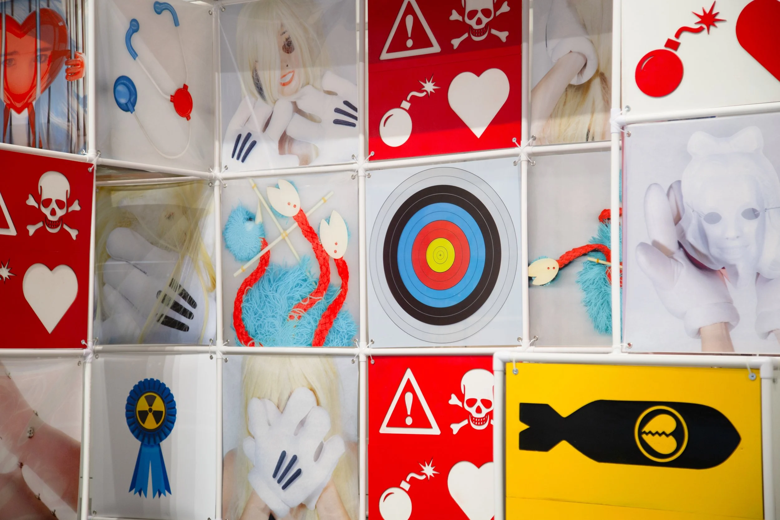 An Attraction (2025) Installation with polyvinyl chloride pipe, inkjet prints on celluloid film, maple plywood coated in federal standard Occupational Safety and Health Administration (OSHA) enamel paint and polyurethane high gloss, silver gromme