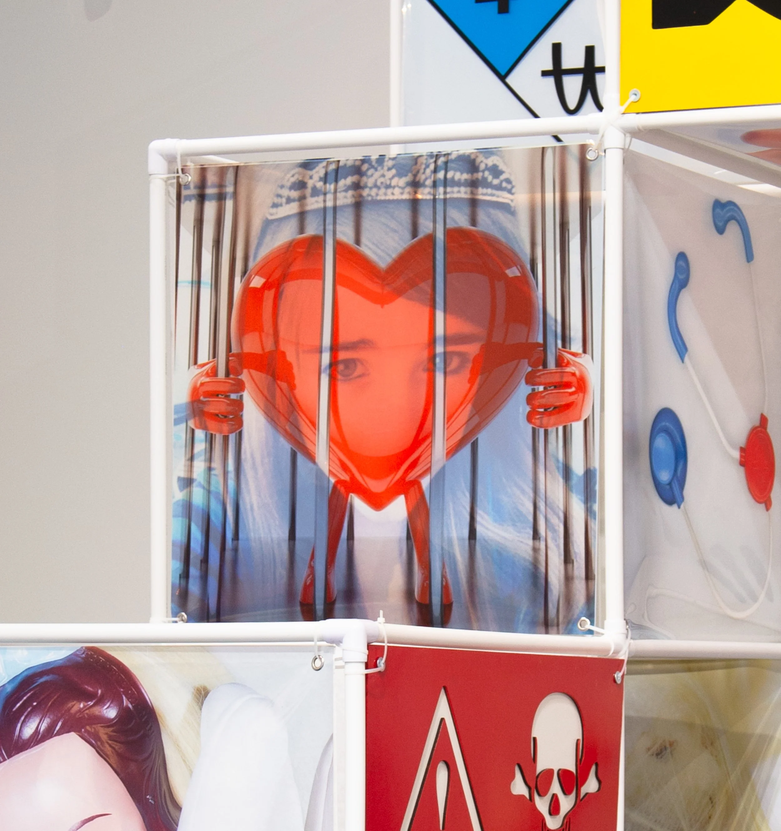An Attraction (2025) Installation with polyvinyl chloride pipe, inkjet prints on celluloid film, maple plywood coated in federal standard Occupational Safety and Health Administration (OSHA) enamel paint and polyurethane high gloss, silver gromme