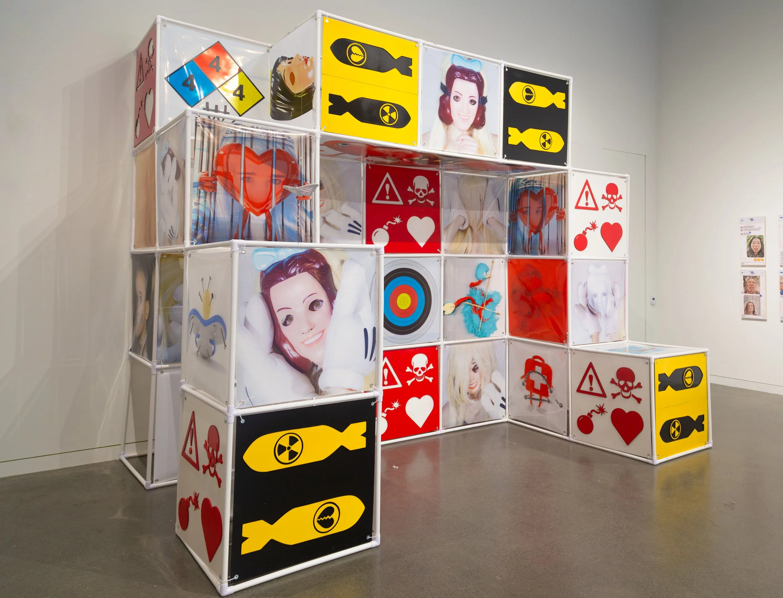 An Attraction (2025) Installation with polyvinyl chloride pipe, inkjet prints on celluloid film, maple plywood coated in federal standard Occupational Safety and Health Administration (OSHA) enamel paint and polyurethane high gloss, silver gromme