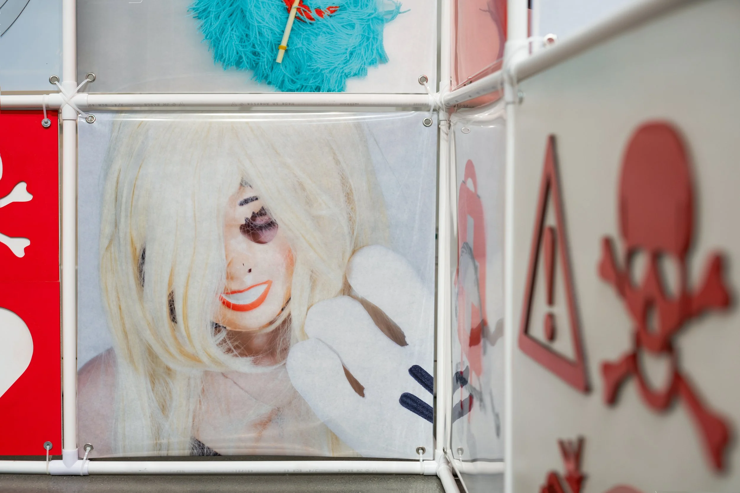 An Attraction (2025) Installation with polyvinyl chloride pipe, inkjet prints on celluloid film, maple plywood coated in federal standard Occupational Safety and Health Administration (OSHA) enamel paint and polyurethane high gloss, silver gromme