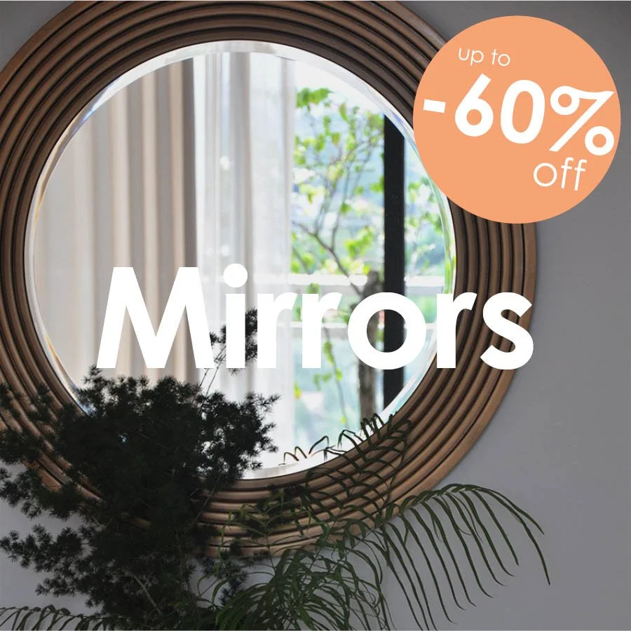 Round fluted wooden wall mirror hanging above a modern wood and black metal console table in a decorated entryway