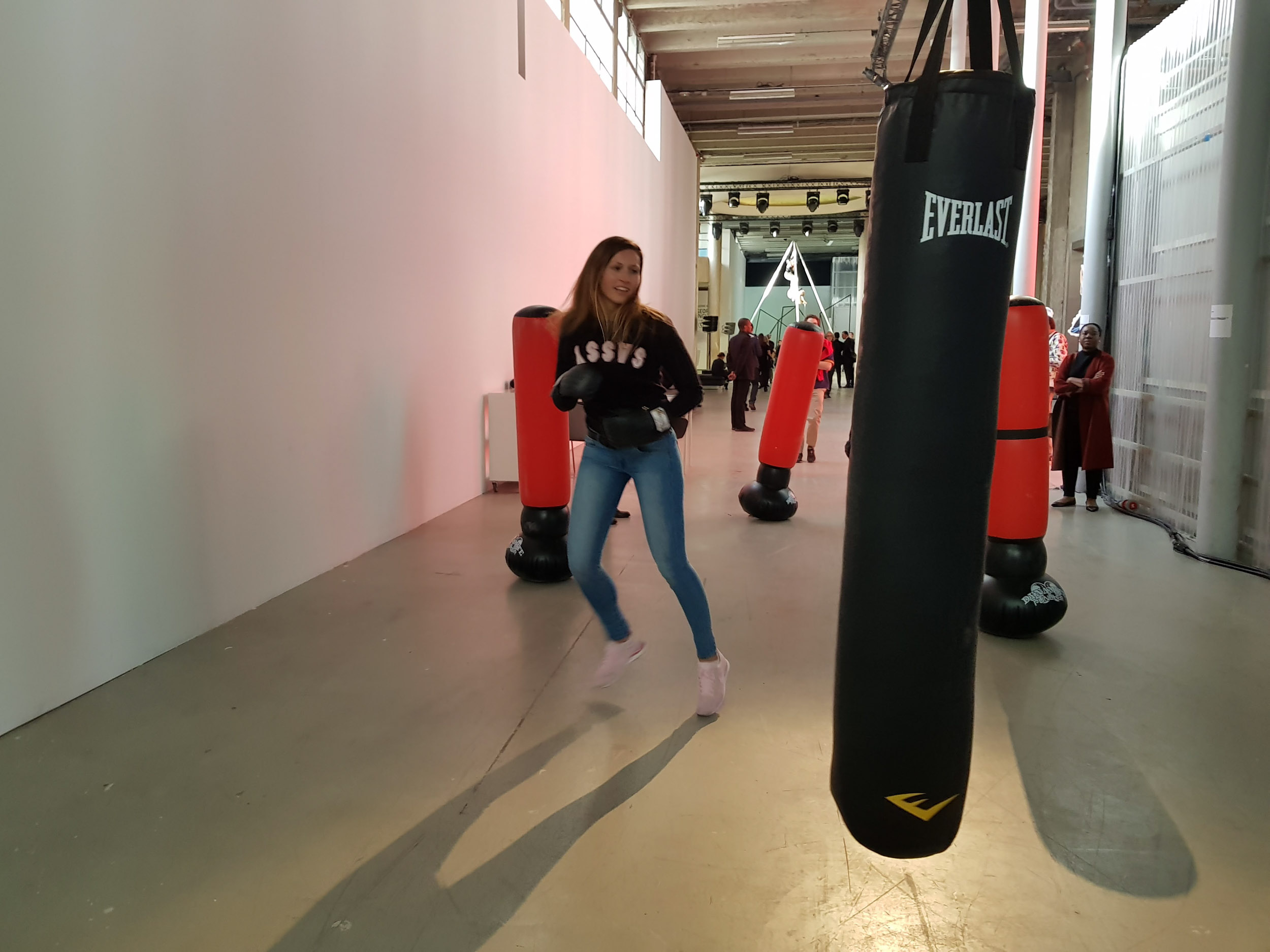  Female athletes of MMA (Mixed Martial Arts, a hybrid combat sport also known as «free-fight» or «ultimate fighting») perform free-fight movements on the punching bags.  The role-playing rule of the installation is that only women are allowed to phys