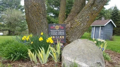 Signs and bright flowers dotting the entrance of the barn