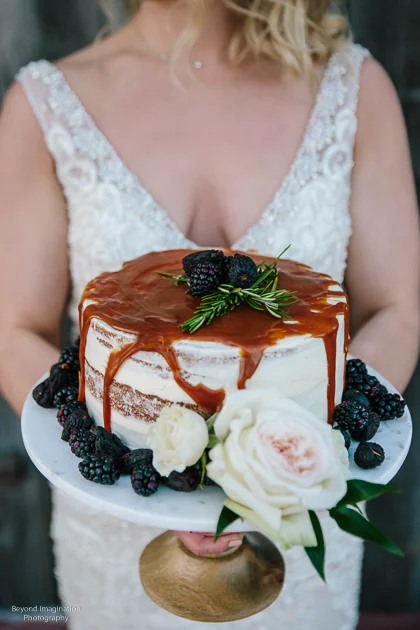 Bride posing with the wedding cake