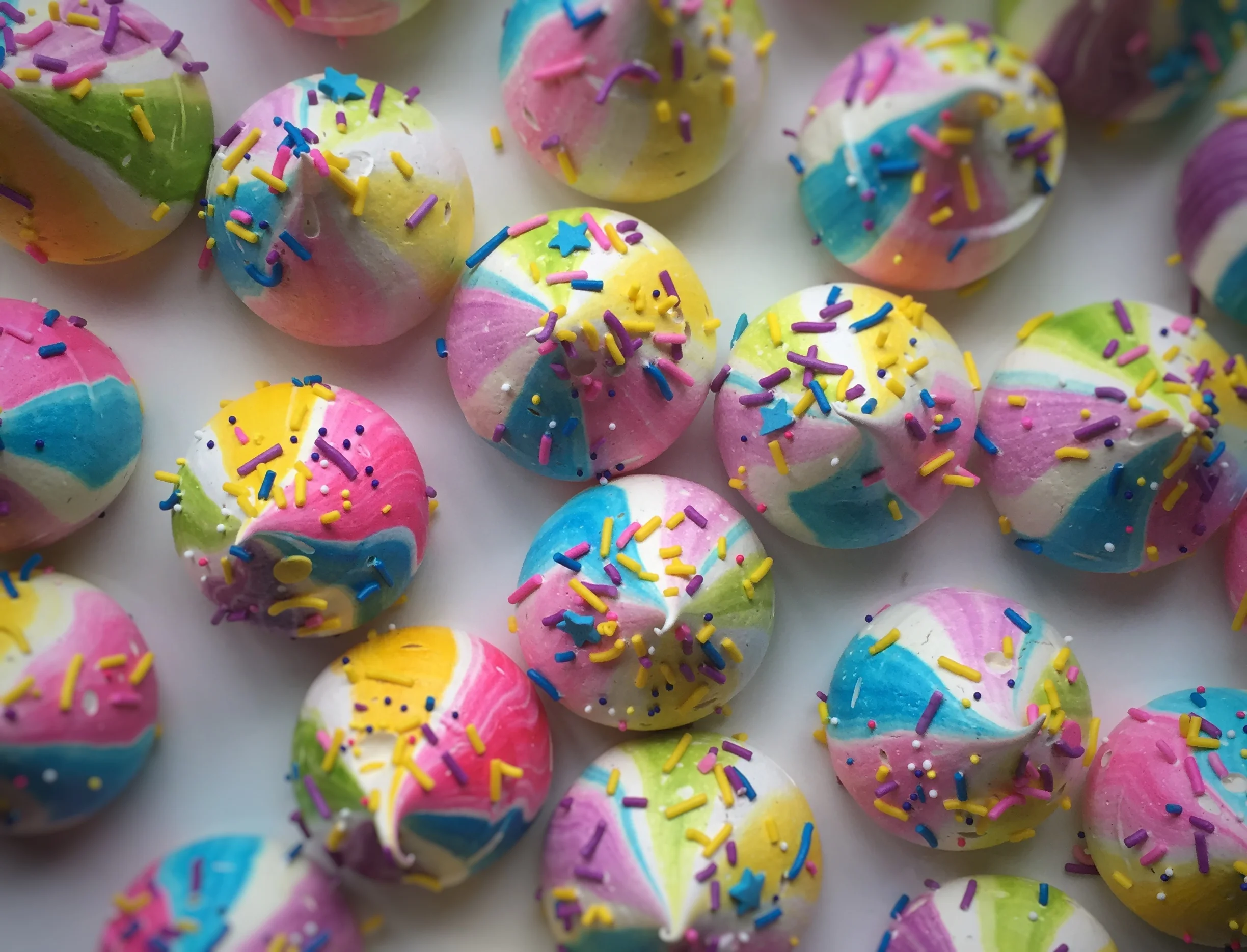 Colorful pastel frosted donuts covered with rainbow sprinkles