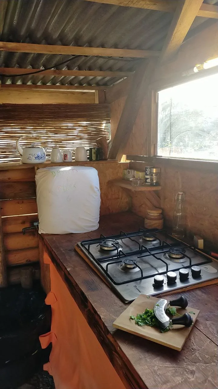 A clean gas stove in the dedicated outdoor kitchen for campervan guests, illuminated by bright morning sunlight.