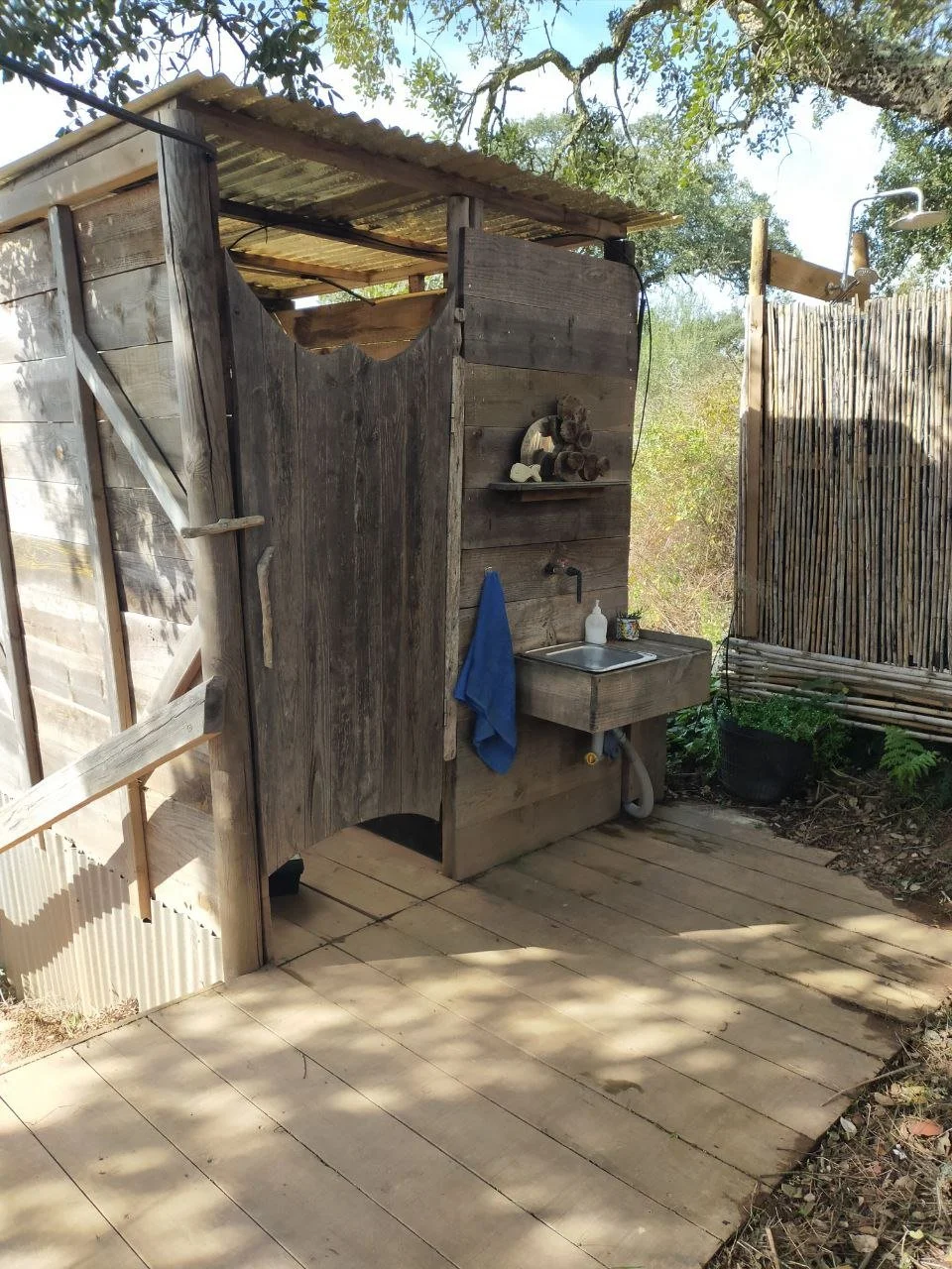 A handcrafted wooden sink and vanity at the outdoor compost toilets, featuring natural textures and eco-friendly design.