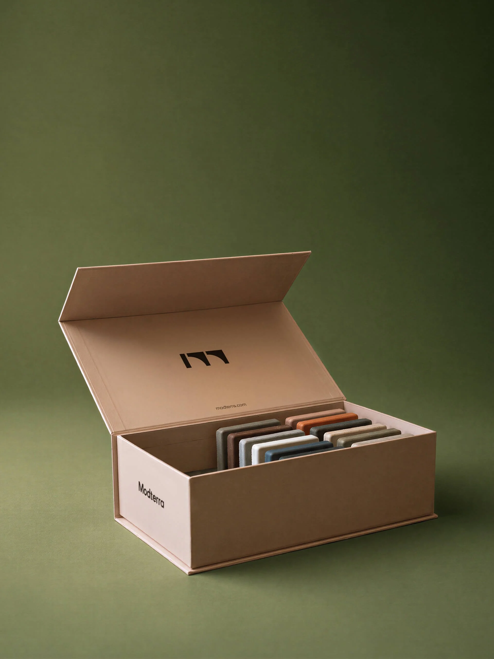 Open Modterra concrete sample set box displaying individually cast GFRC concrete color sample tiles.
