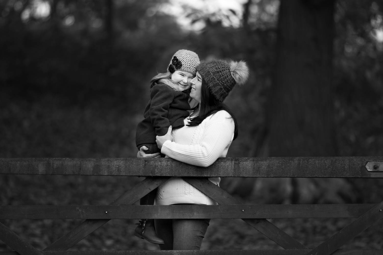  Mother and dughter posing against a gate during an Autumn family photoshoot at Ampthill Park in Bedford. 