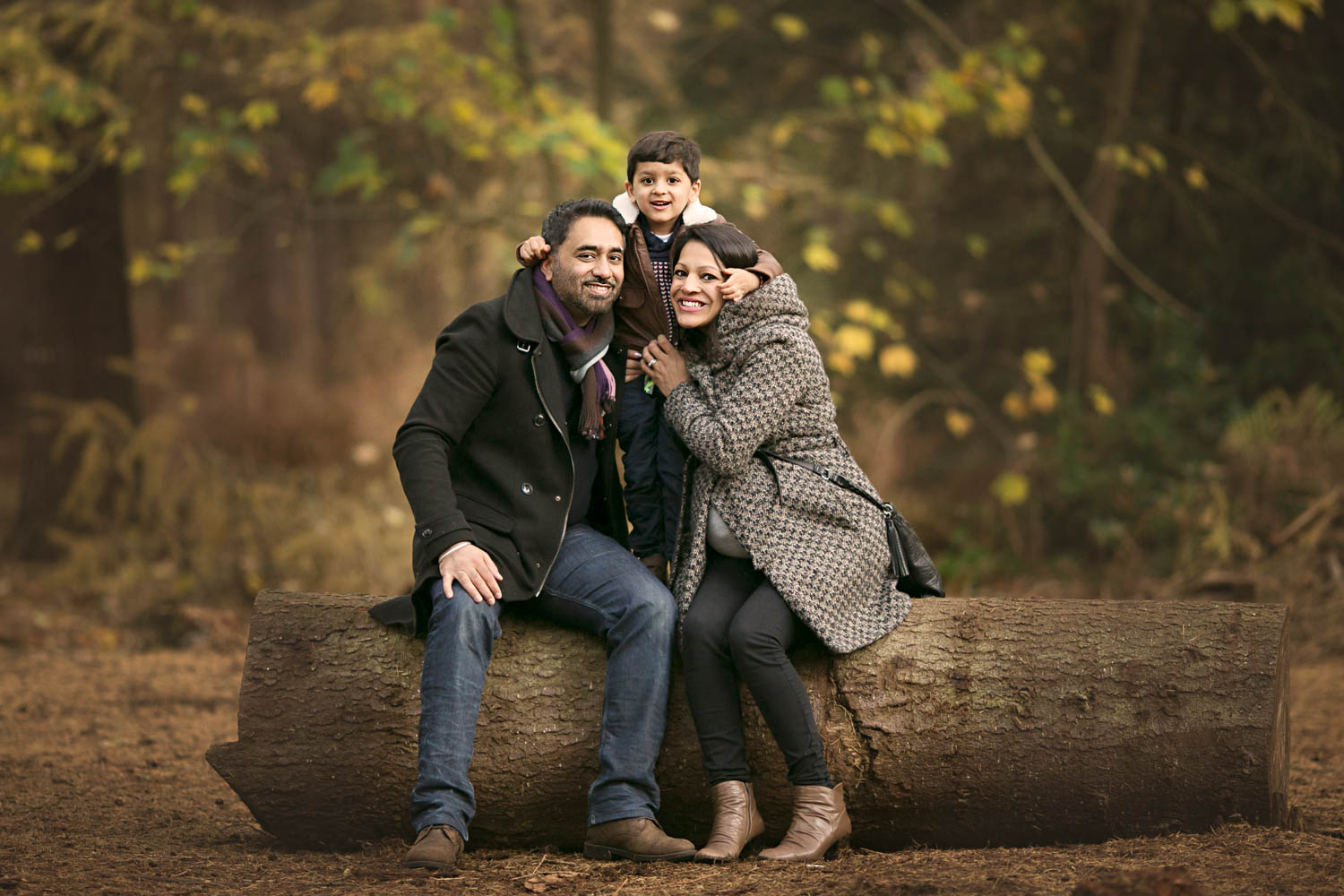  Family posing for portrait during autumn photoshoot at Rushmere Park, Bedfordshire 