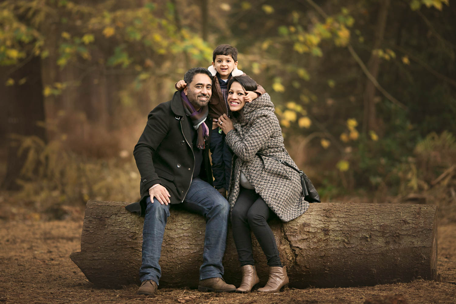 Family posing for portrait during autumn photoshoot at Rushmere Park, Bedfordshire