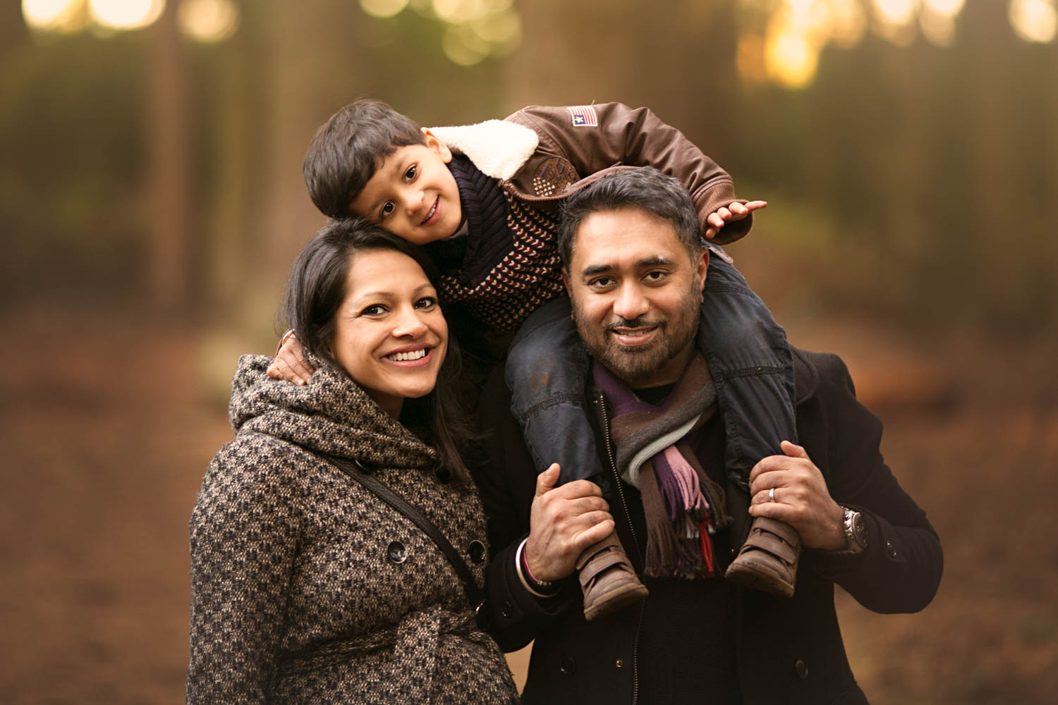  Family posing for portrait during an Autumn photoshoot at Rushmere Park, Bedfordshire 