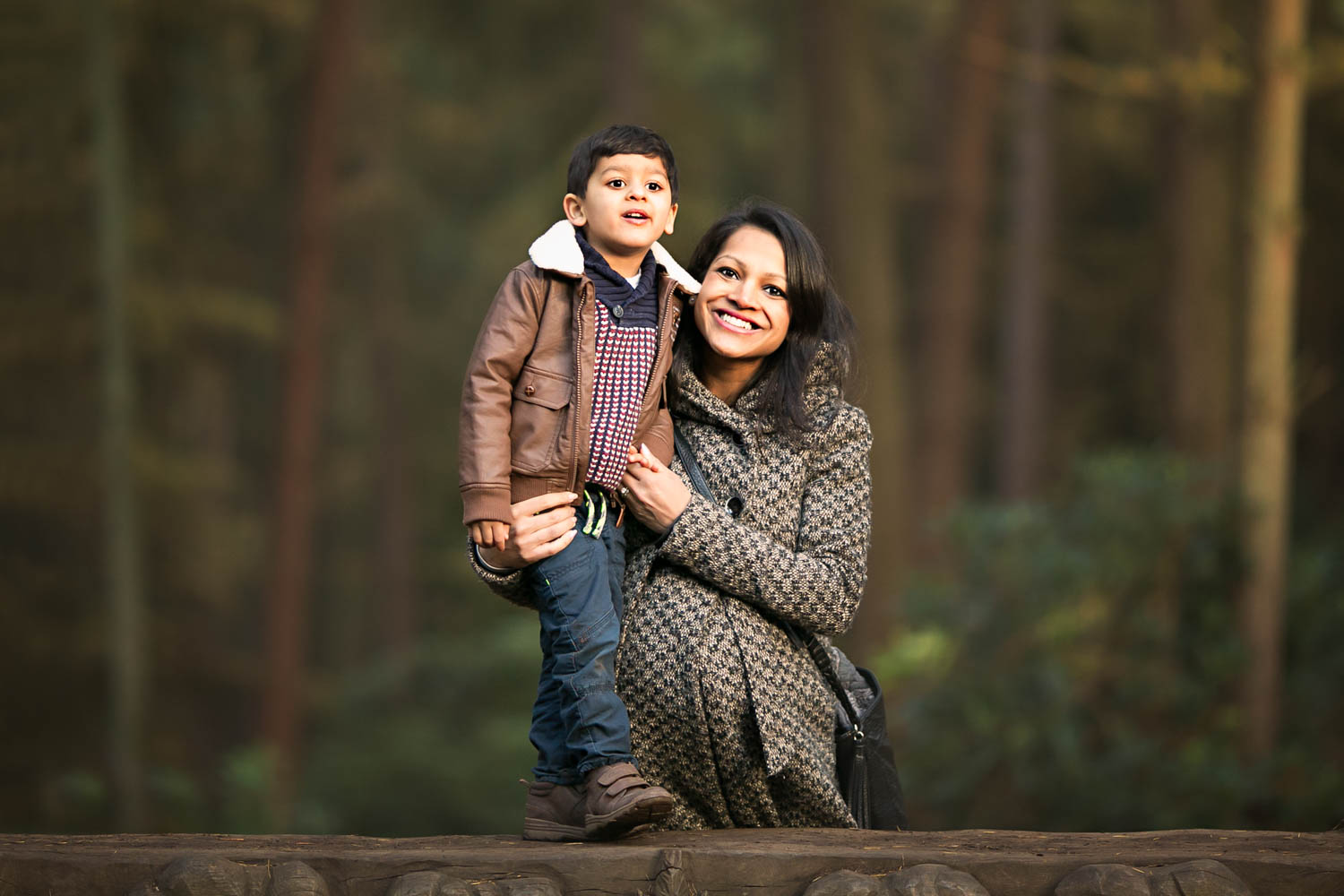 Mother and Son pose for a Family portrait during an Autumn family photoshoot at Rushmere Park in Bedfordshire.