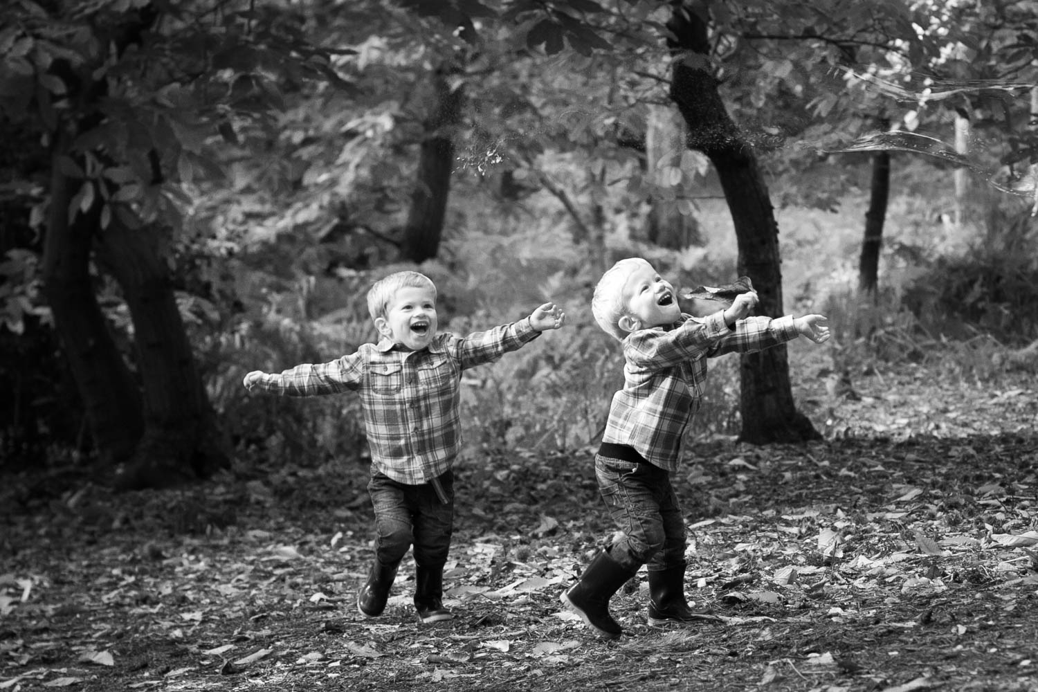  Twin boys chasing bubbles during a family photoshoot. 