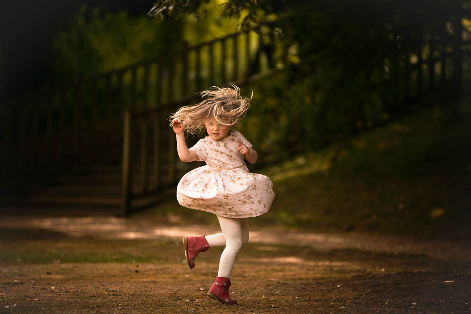  little girl spinning during child photography session at Castle Ashby, Northampton. 