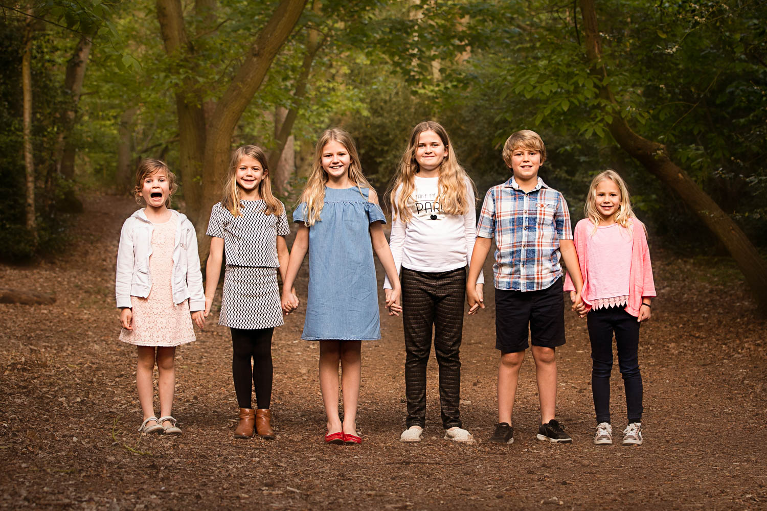  Siblings and cousins line up for family portait during Autumn photoshoot at Ampthill Park, Bedford. 