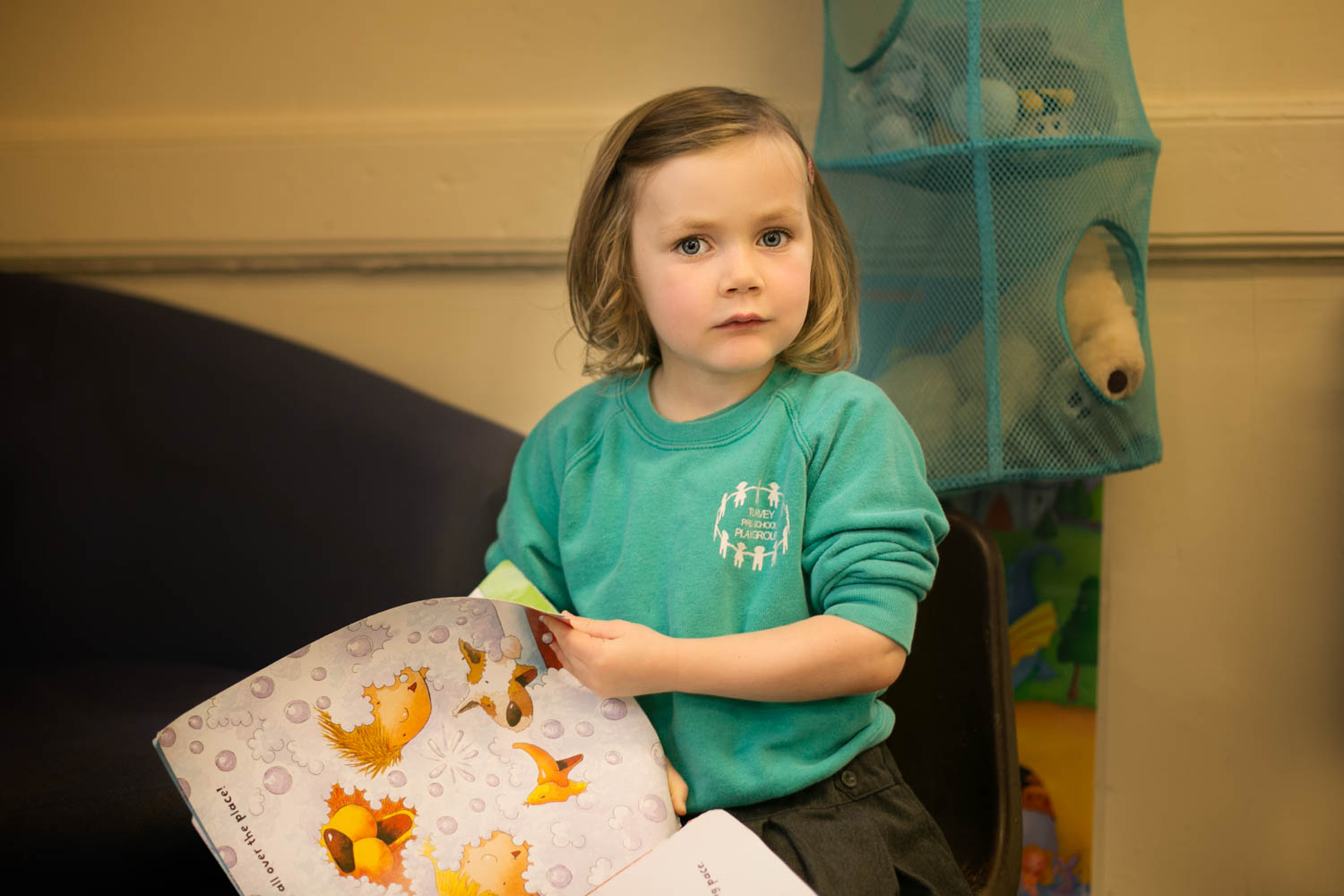  Girl reading a book during preschool photoshoot in Turvey Bedford. 