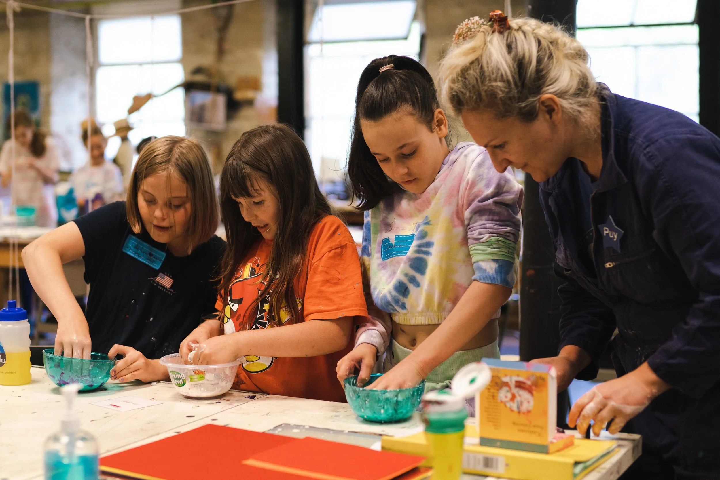 Three children and a tutor making art work.
