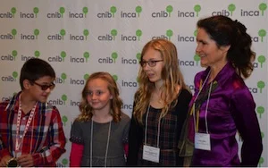 Susan Hughes (right), an adjudicator in the Braille Writing Contest for Kids, in 2016, with (left to right) winning writers Joshua Schramm; Marie-Eve Letourneau; and Margaret Ingleson.