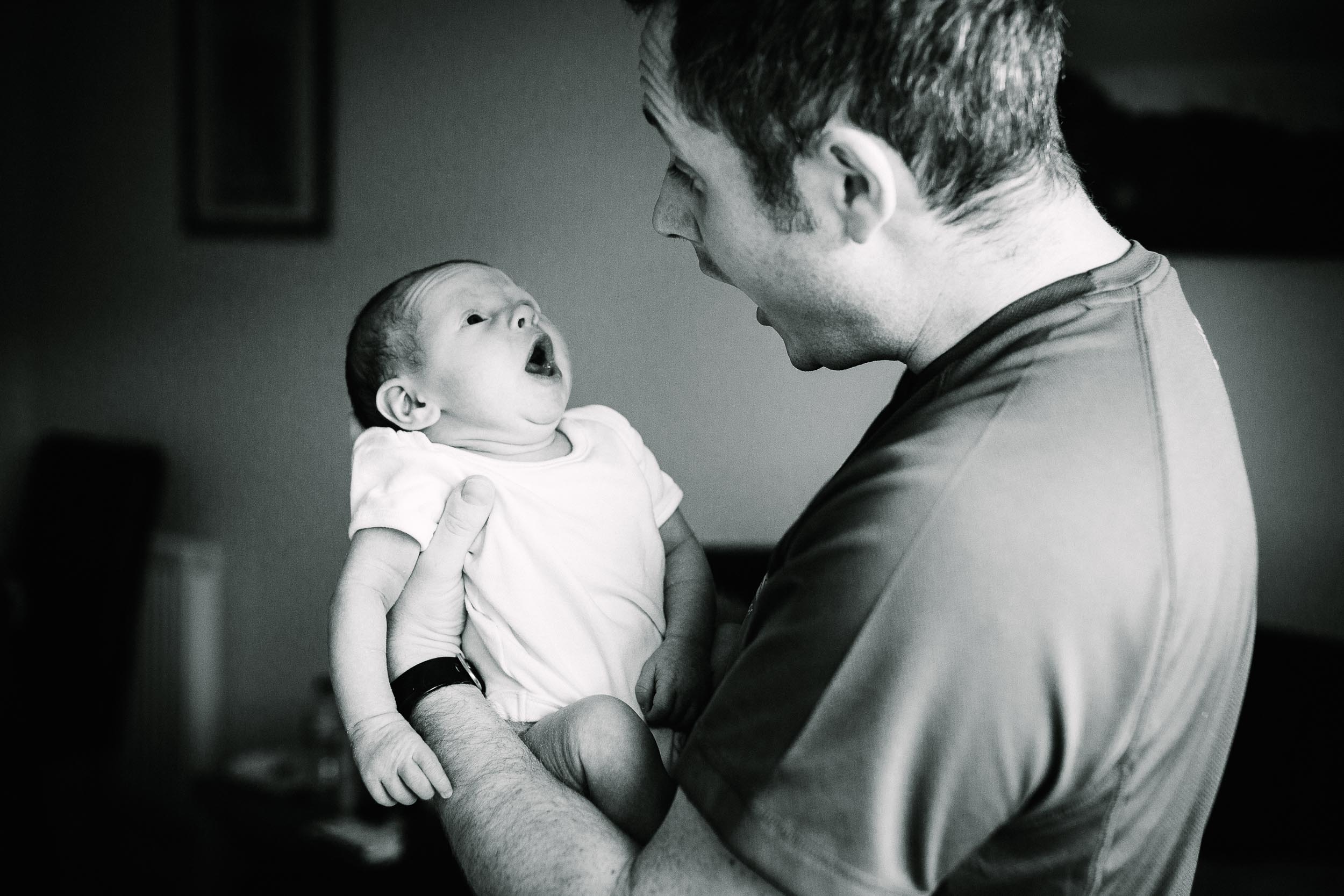 Father imitates his newborn baby yawning, photo in black and white by Emma Godfrey.