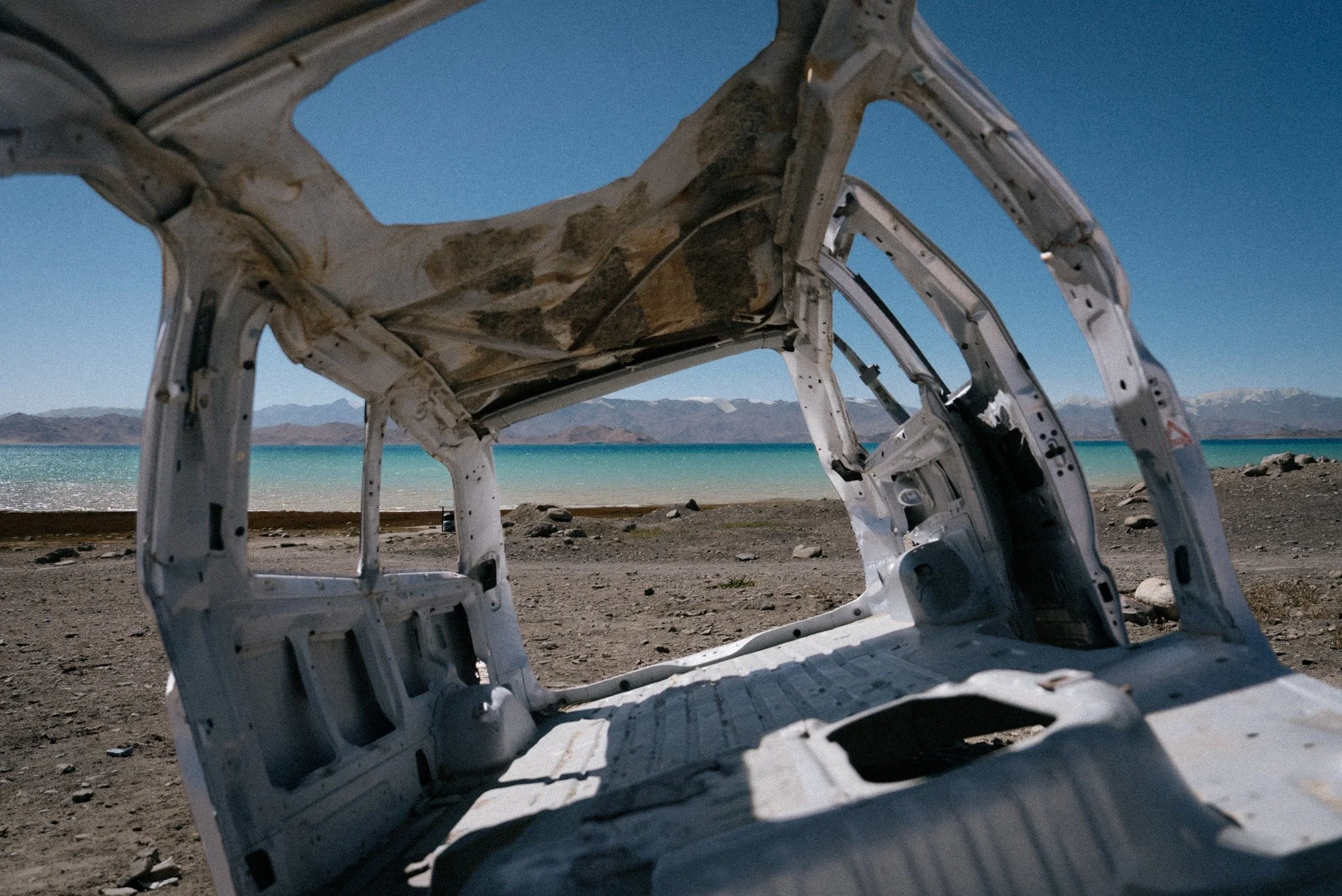 Scattered shells of cars around Karakul Lake, Tajikistan. 

At nearly 4000m elevation, this high-altitude lake was formed by a metorite strike millions of years ago and fills with glacial runoff, giving it that unique colour.

 #karakullake #tajikist