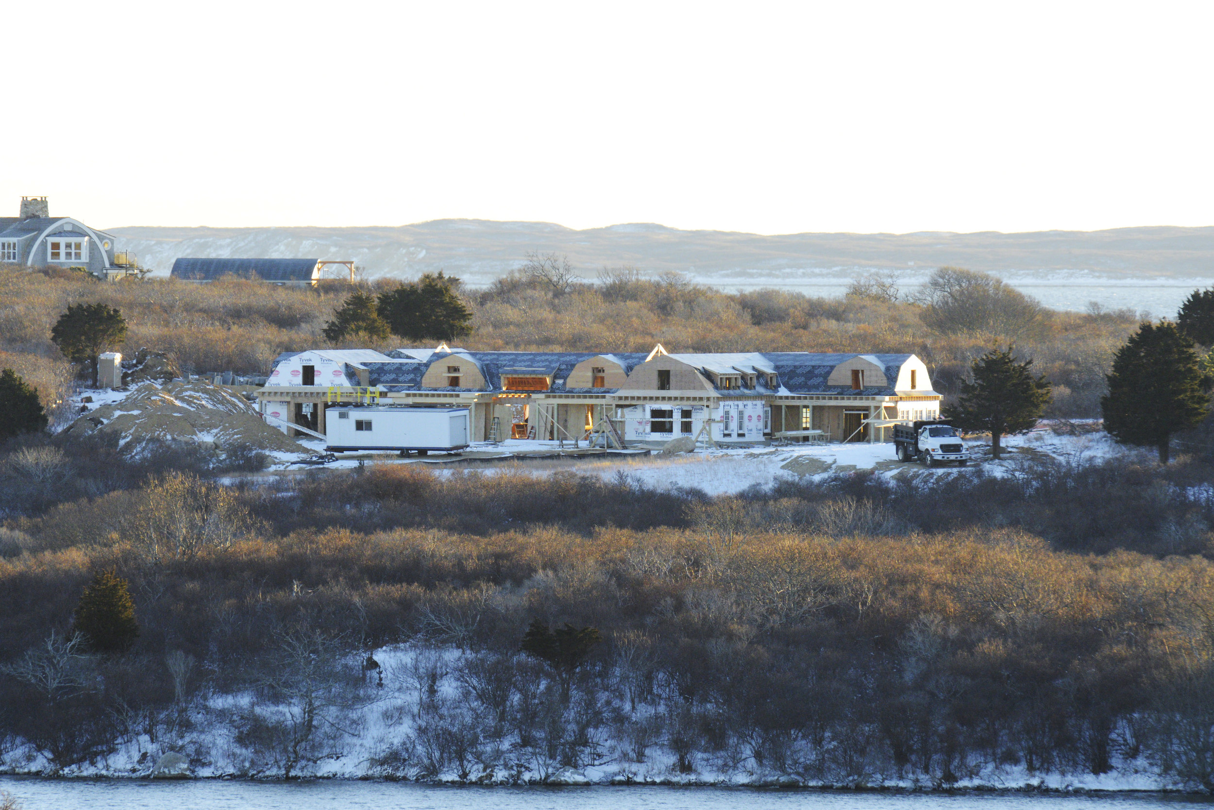 A Martha's Vineyard mansion under construction with neighboring mansion under construction in distance