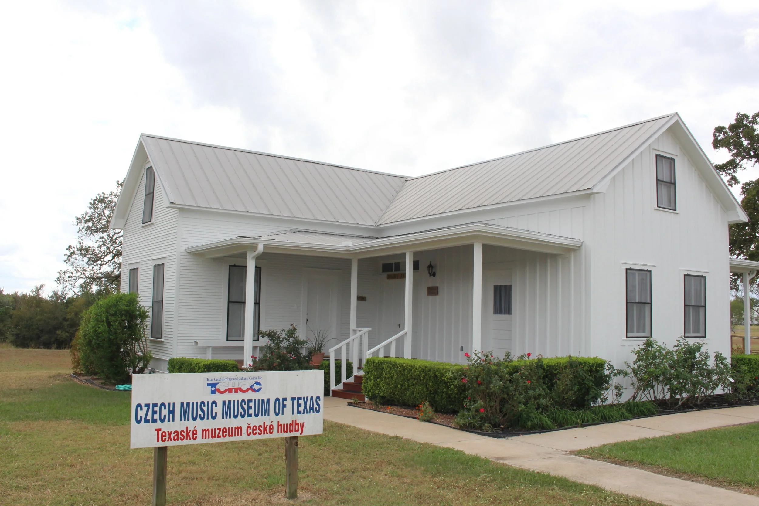 Development of TCHCC began when the Kalich House, restored by volunteers, became the first TCHCC Visitors’ Center. This historic 1890s Texas-Czech farmhouse was donated by Peggy Kalich of Schulenburg. The house was moved to the site on June 22, 2000 by Káňa Brothers, Inc. House Leveling and Moving and then transformed into the Visitors’ Center, which temporarily housed the office, gift shop, library, and display area. The restoration efforts took approximately 3,109 hours with some 80 volunteers ranging in age from 2 to 80. Major restoration of the roof and porches was done by Robert Slovak Construction and volunteers from Ennis. It served as the Visitors’ Center until 2009 when the main building was completed. It is now TCHCC’s Czech Music Museum of Texas displaying music memorabilia in four musical genres: Classical Music of Czech Composers, Spiritual/Liturgical Music, Folk Music and Dance, and Polka/Czech Brass Music.