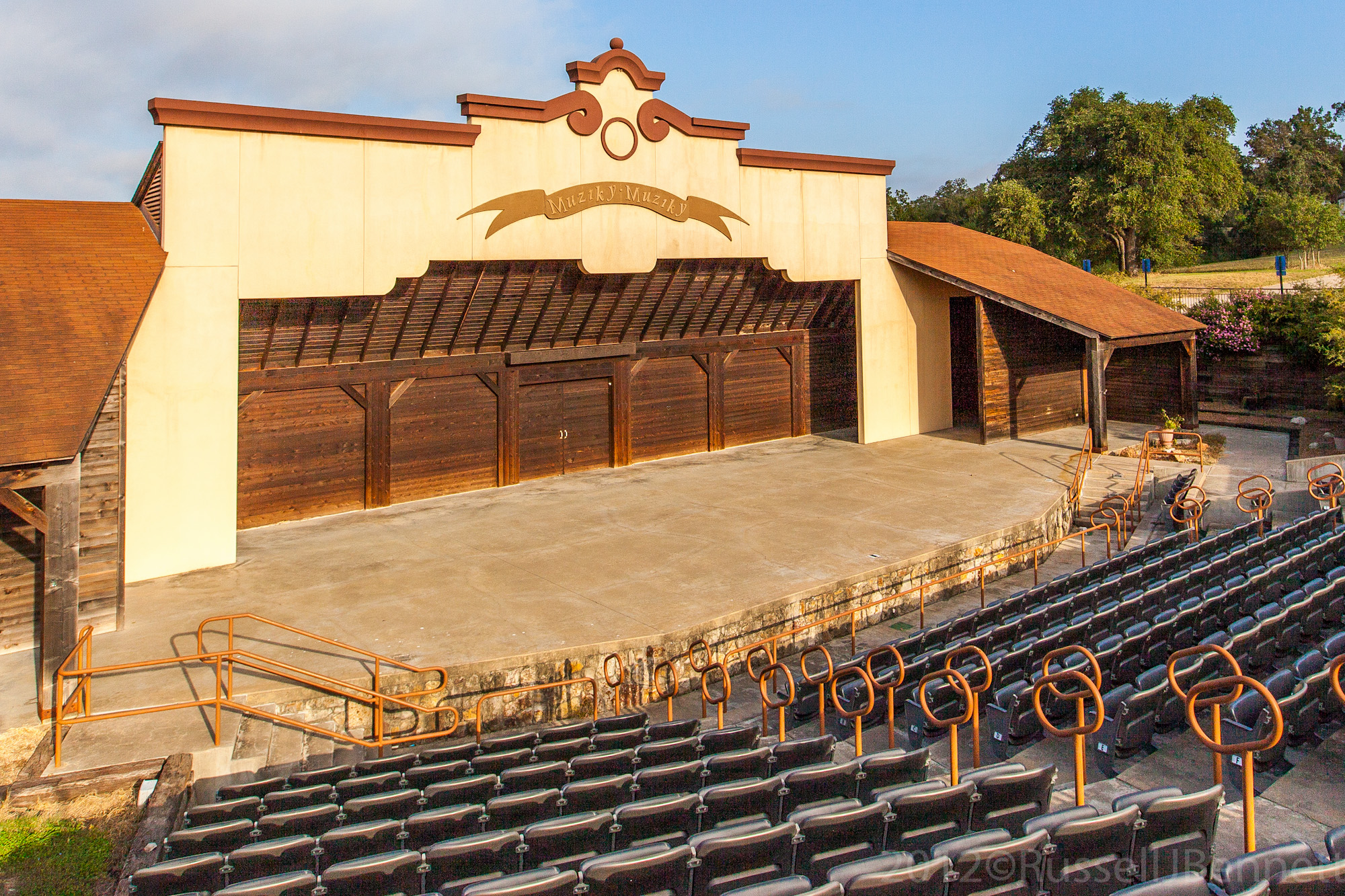 Thanks to an initial grant by the LCRA and a matching grant by La Grange resident Sanford Schmid, the amphitheater was built in 2000. The 5,500-square-foot facility is built in a Texas Czech style and includes an open stage, dressing/meeting rooms, restrooms, and prop storage area. Music is very special in the life of Czechs. The Czech saying Muziky, Muziky (Music, Music) adorns the top of the stage. The facility is available for rent and used for musical performances, theatrical plays, presentations, and outdoor weddings. Muziky, Muziky performances are part of the Czech Heritage Festival held each October.