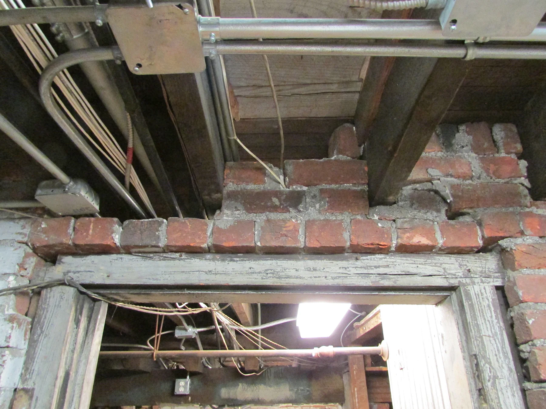 A damaged wooden lintel beneath the church.