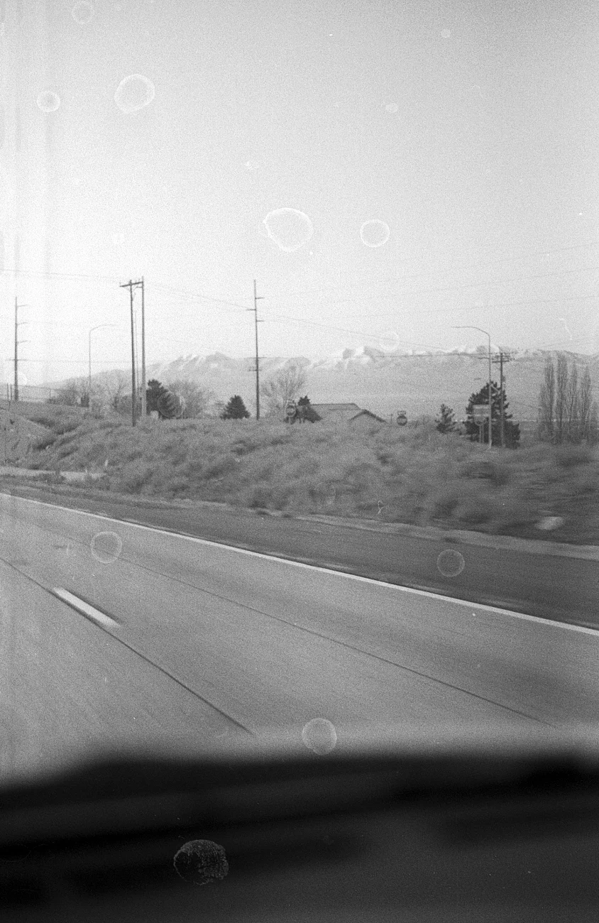 Taking pictures with a fully manual camera while driving is like texting while driving - only a lot worse