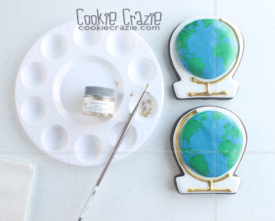 Make a mixture of gold dust and alcohol (or clear extract, i.e. almond) and paint over the frame/base of the globe as shown above.