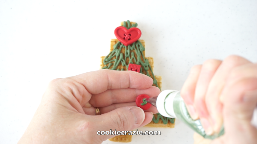  Once the clay has been frozen for more than an hour, you should be able to pop the buttons out of the mold and place directly on the cookie. If preferred, you can mold the buttons, pop them out, dry them on parchment paper overnight, and then "glue"